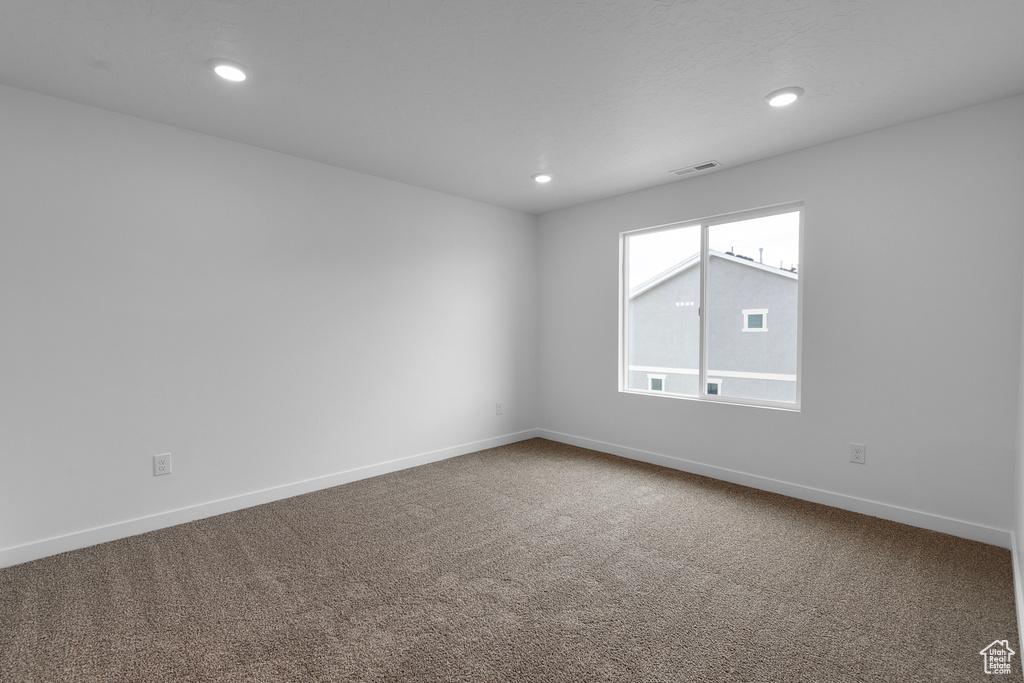 Carpeted spare room featuring recessed lighting