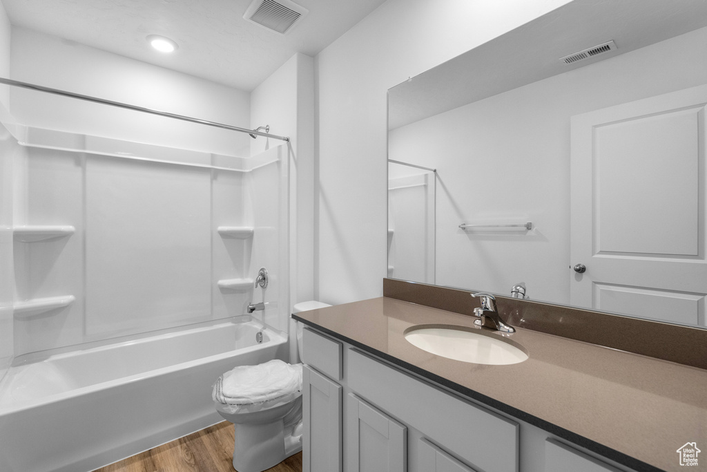 Full bath featuring wood finished floors, vanity, and shower / washtub combination
