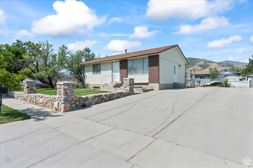 Ranch-style house featuring a mountain view, concrete driveway, and brick siding