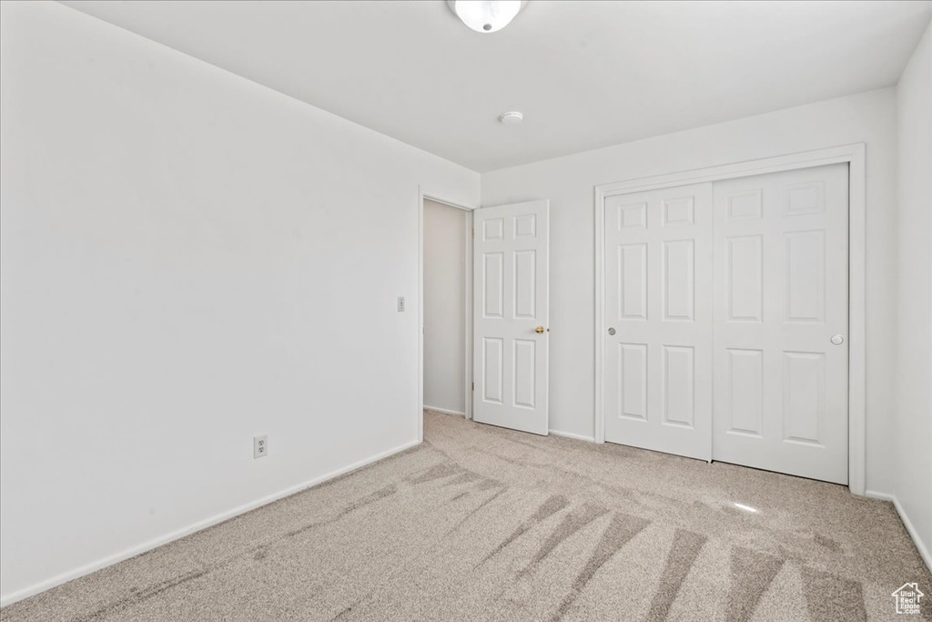 Unfurnished bedroom featuring carpet floors and a closet