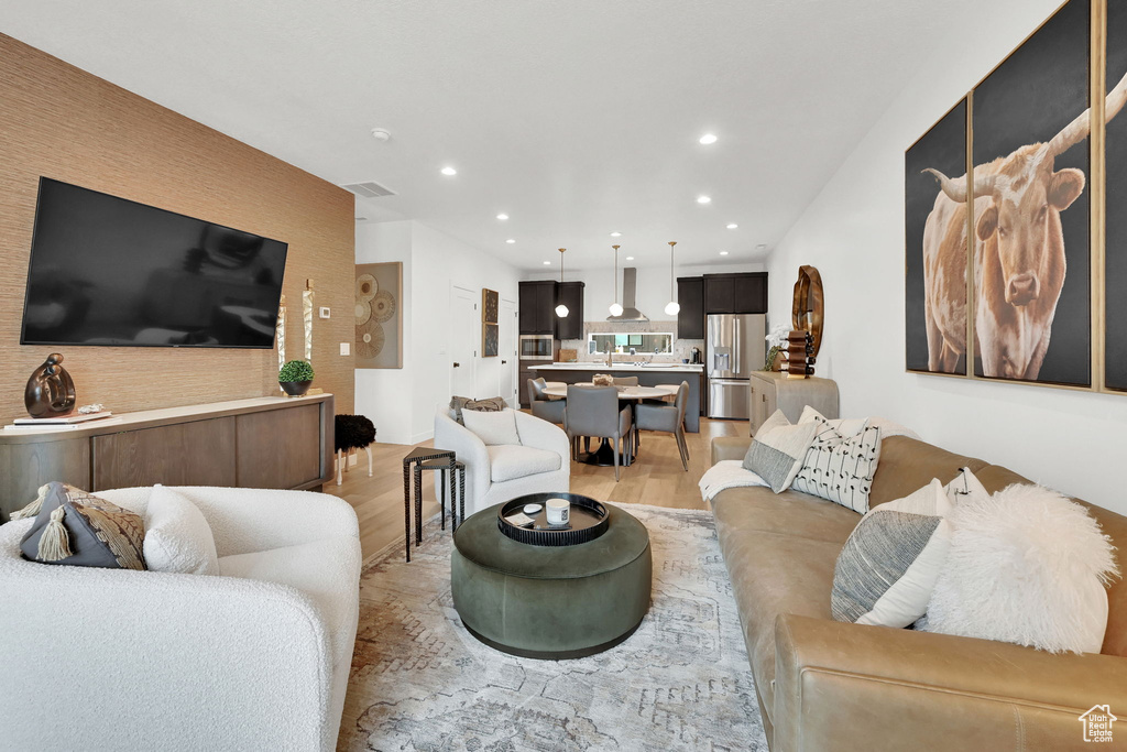 Living area featuring light wood finished floors and recessed lighting