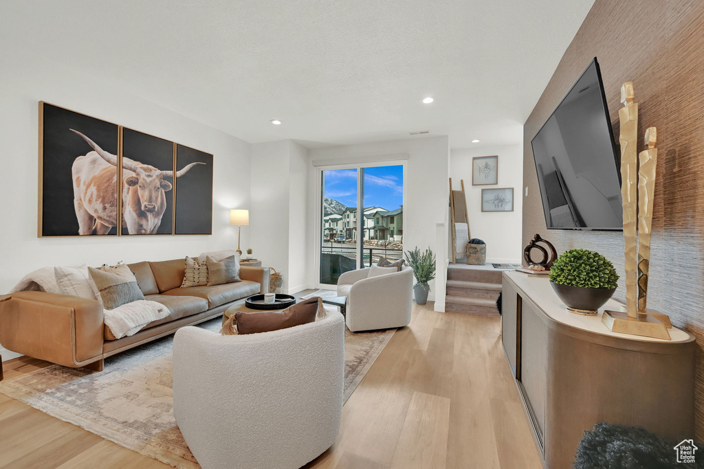 Living room with light wood-style floors and recessed lighting