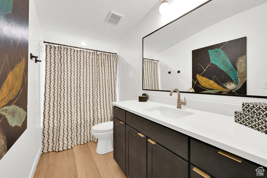 Full bath with wood finished floors, vanity, and a shower with curtain