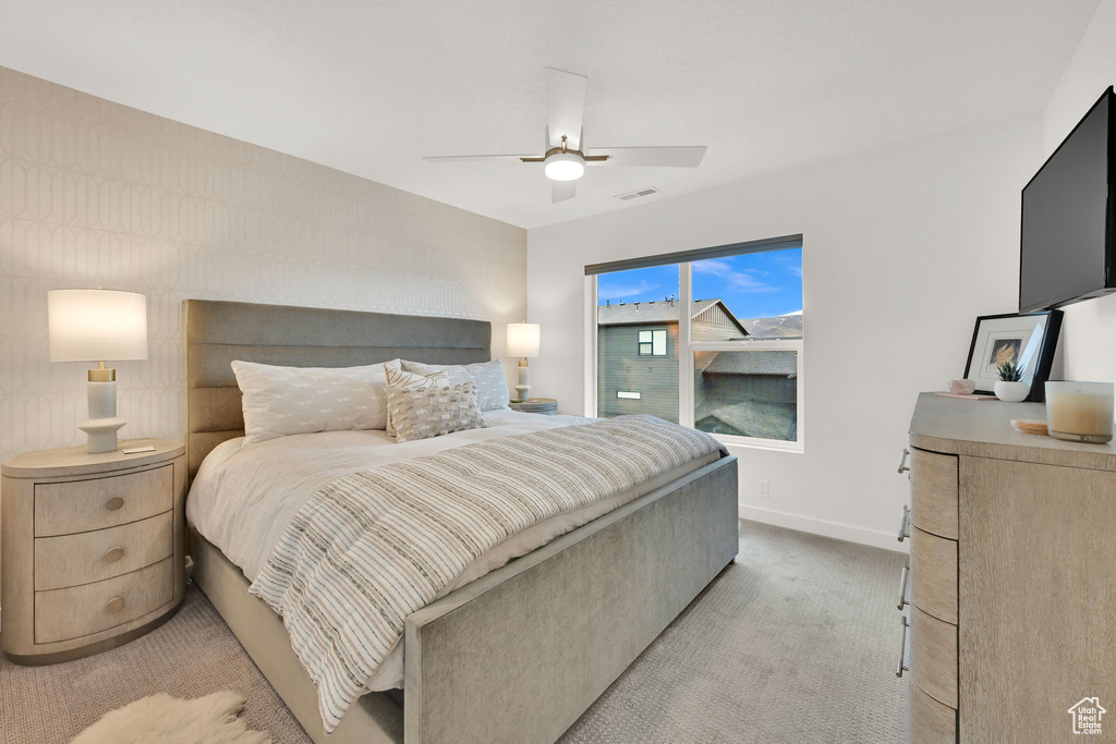 Bedroom with light colored carpet and ceiling fan
