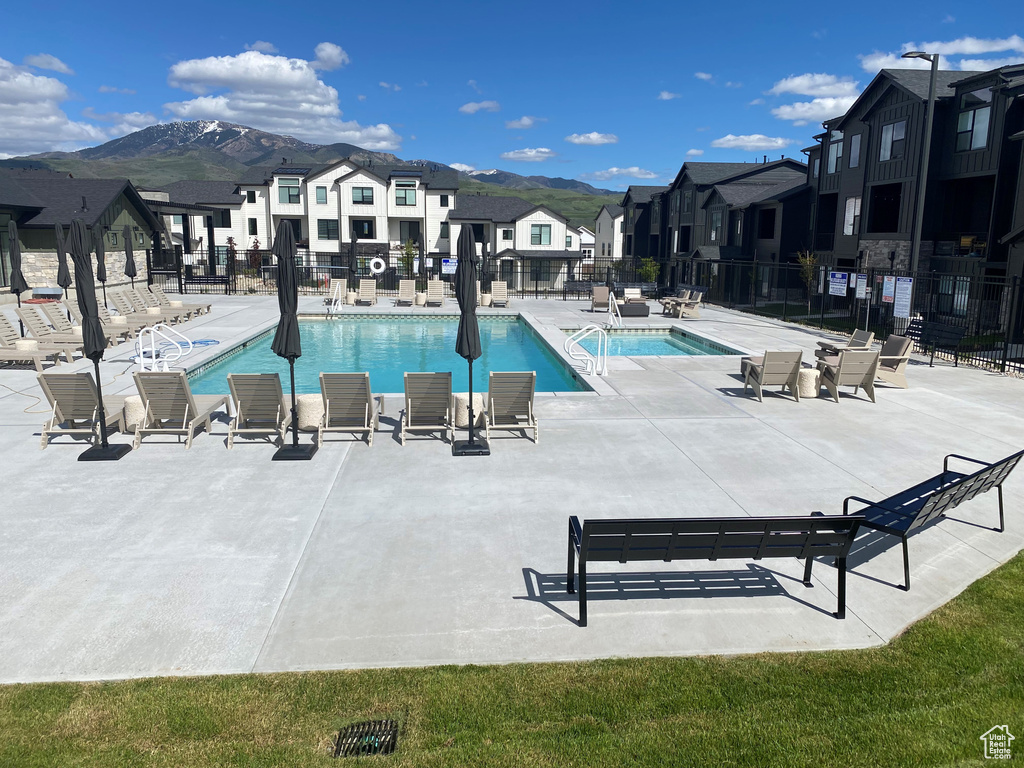 Community pool with a residential view, a mountain view, and a patio area