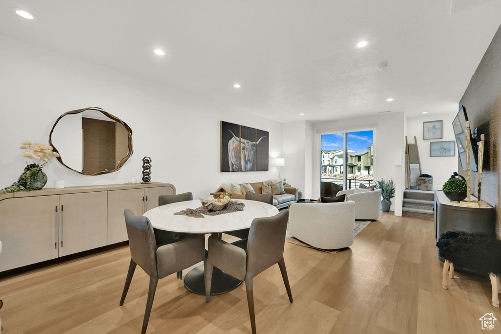 Dining room featuring light wood-type flooring, recessed lighting, and stairs