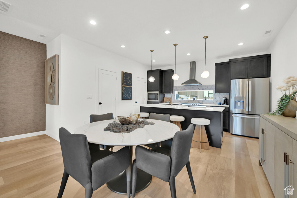Dining room with light wood-type flooring and recessed lighting