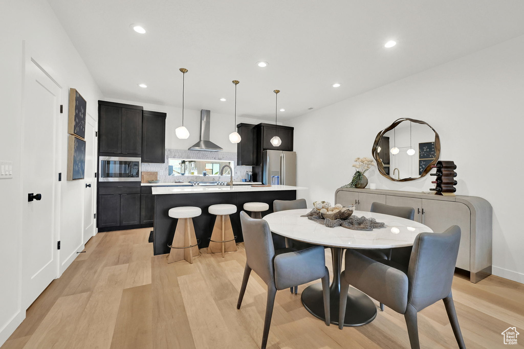 Dining area with light wood-style floors and recessed lighting