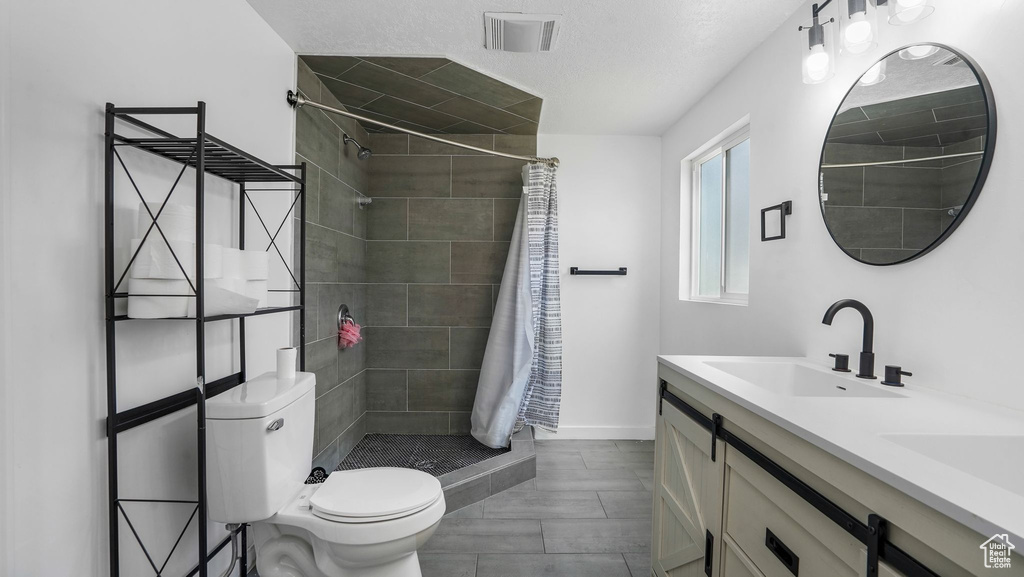 Full bathroom with tiled shower and double vanity