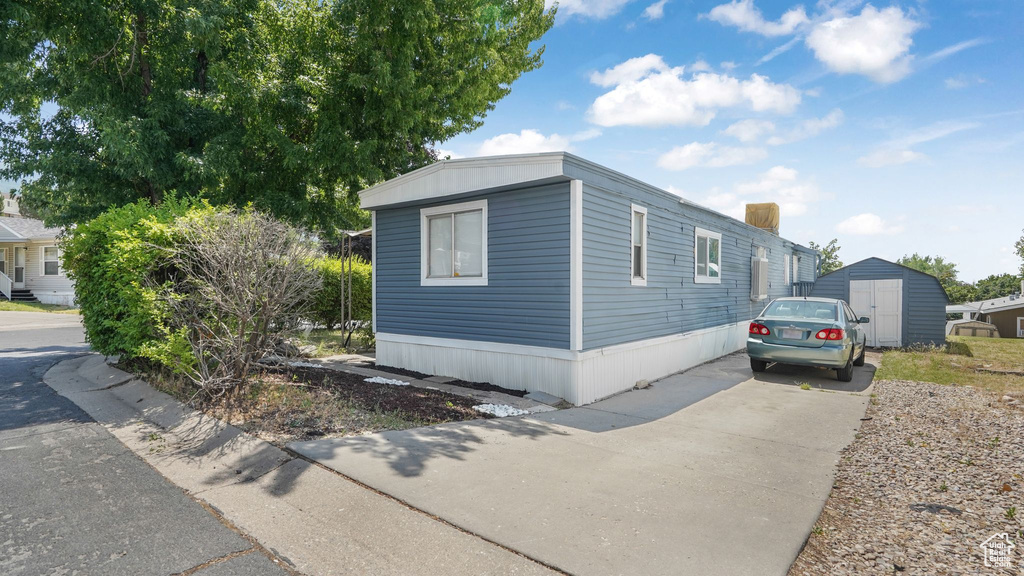 View of front of property with a storage unit and driveway