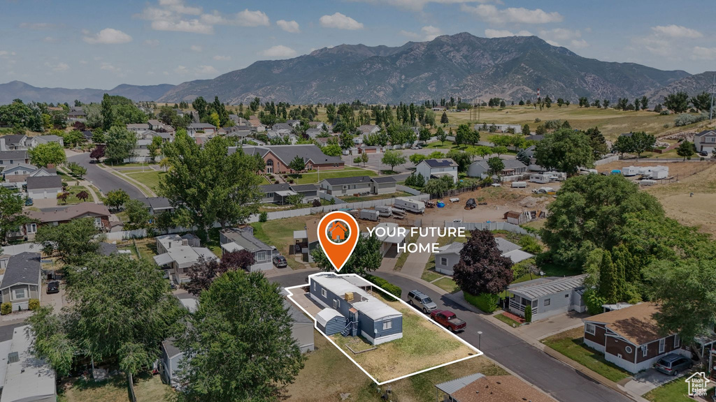 Aerial perspective of suburban area with property boundaries highlighted and a mountainous background