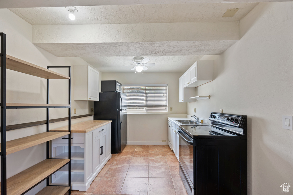 Kitchen featuring white cabinets, a sink, ceiling fan, a textured ceiling, and black appliances