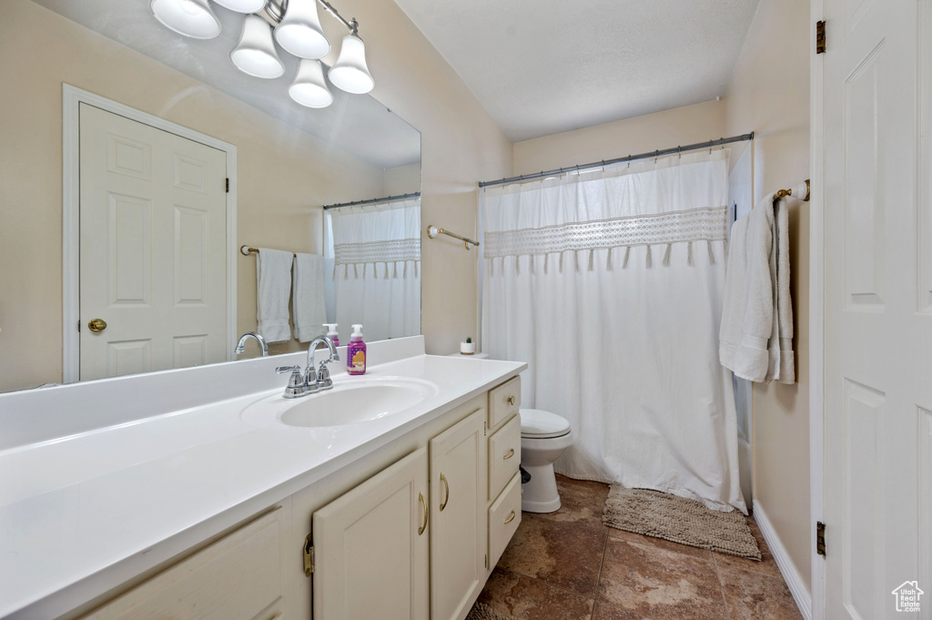 Full bath featuring toilet, curtained shower, and vanity