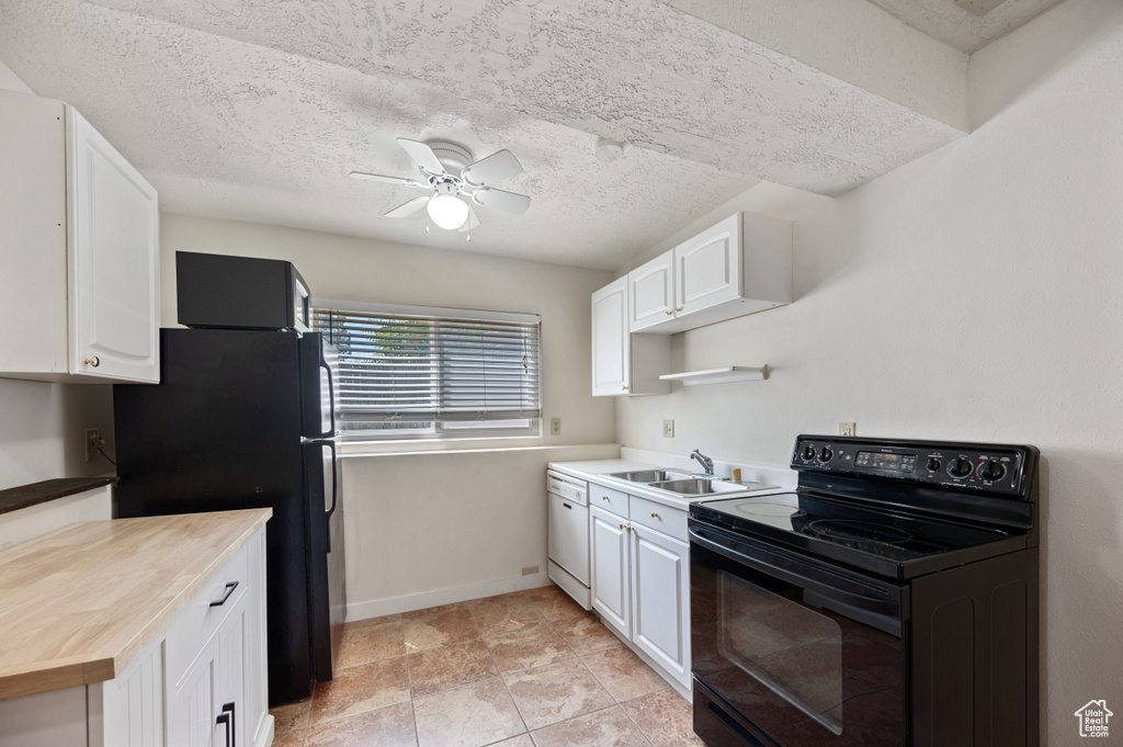 Kitchen featuring white cabinets, a sink, black appliances, and a ceiling fan