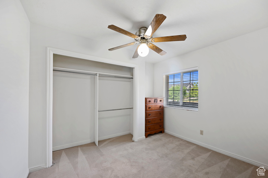 Unfurnished bedroom featuring a closet, baseboards, a ceiling fan, and carpet floors