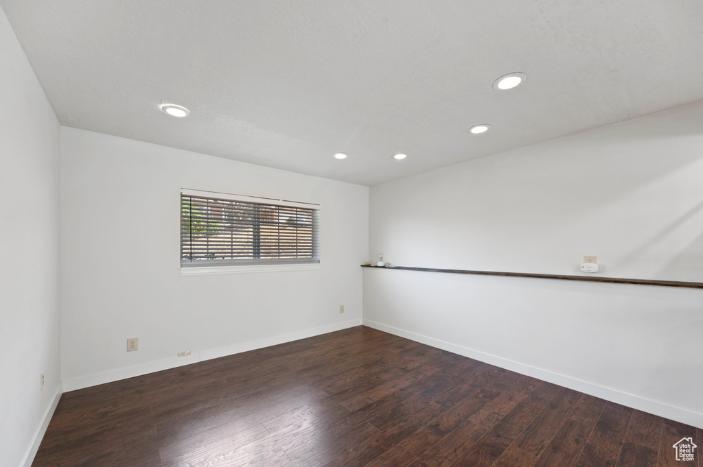 Unfurnished room with wood finished floors, baseboards, and recessed lighting