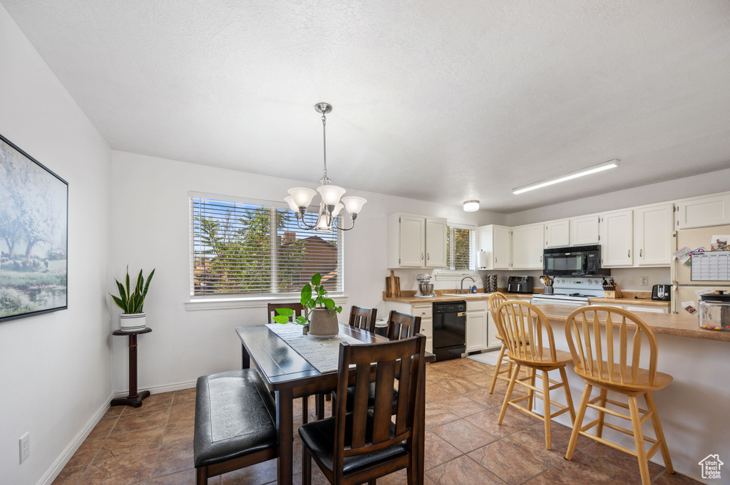 Dining room featuring a notable chandelier and baseboards