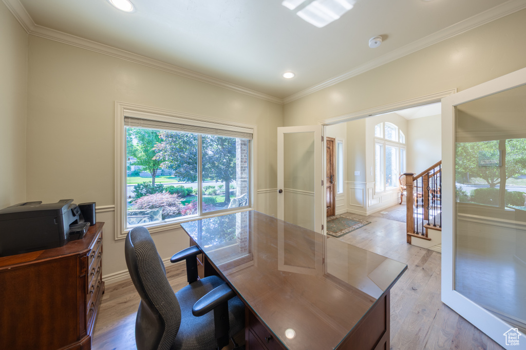 Home office featuring light wood-type flooring, healthy amount of natural light, french doors, crown molding, and recessed lighting