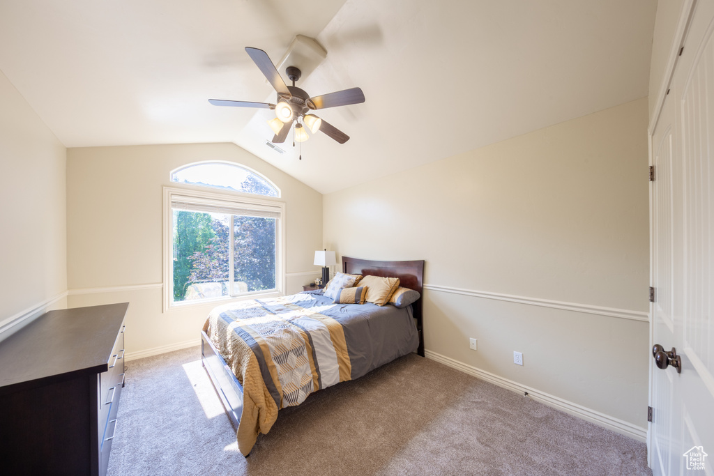 Bedroom featuring vaulted ceiling, light carpet, and ceiling fan
