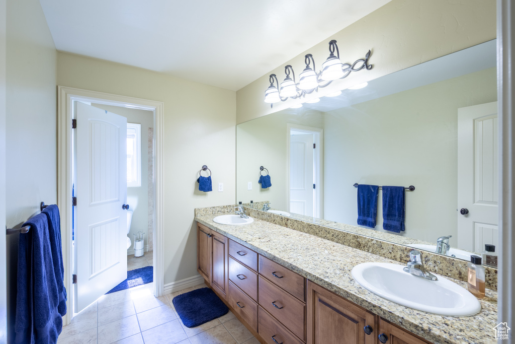 Bathroom with double vanity and tile patterned floors