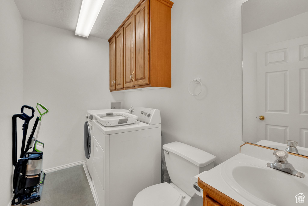 Bathroom with washing machine and clothes dryer and vanity