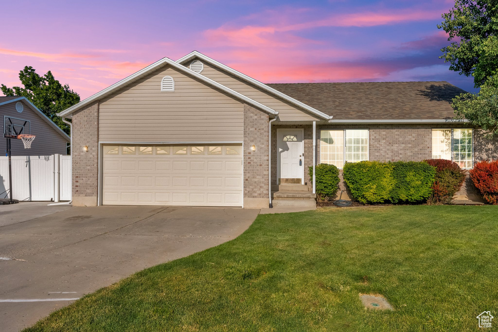 Single story home featuring brick siding, concrete driveway, an attached garage, and a shingled roof