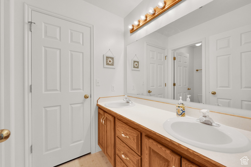 Bathroom featuring double vanity and toilet