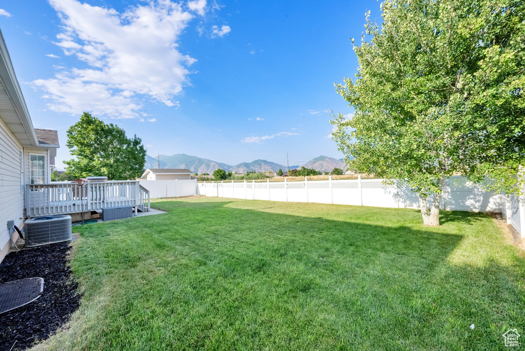 Fenced backyard featuring a deck with mountain view