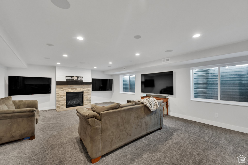 Living area with carpet flooring, recessed lighting, and a fireplace