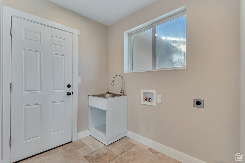 Washroom featuring hookup for an electric dryer, washer hookup, and light stone finish floors