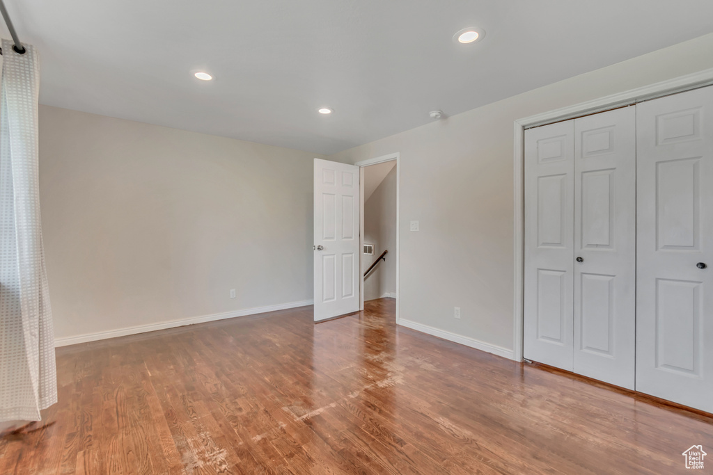 Unfurnished bedroom featuring wood finished floors, a closet, and recessed lighting