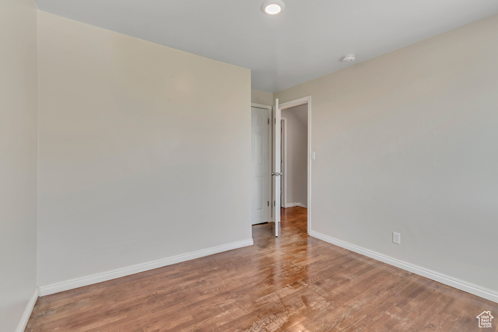 Unfurnished room with a smoke detector and wood finished floors