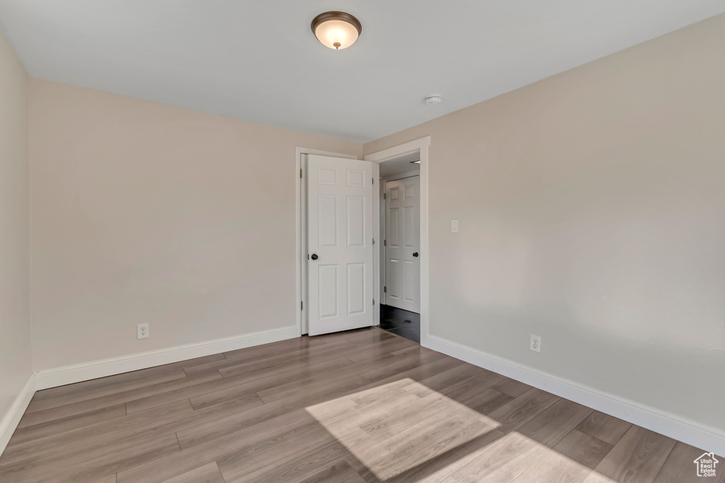 Unfurnished room with wood finished floors and a smoke detector