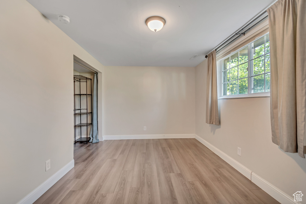 Unfurnished room with light wood-style flooring and a smoke detector