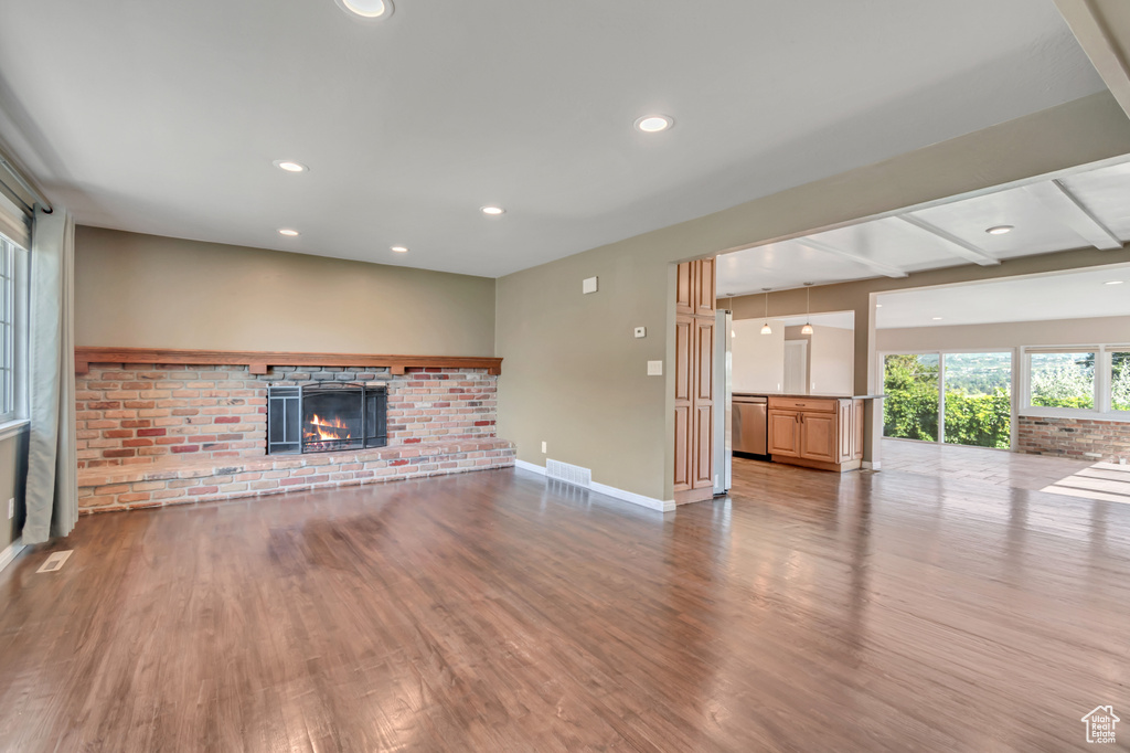 Unfurnished living room with a fireplace, wood finished floors, and recessed lighting