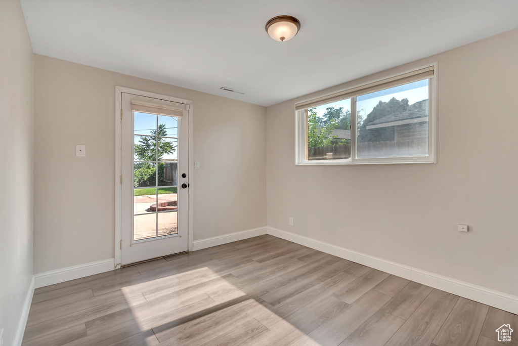 Empty room with plenty of natural light and light wood-style floors