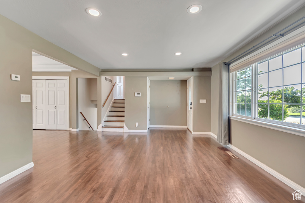Unfurnished room with stairway, wood finished floors, and recessed lighting