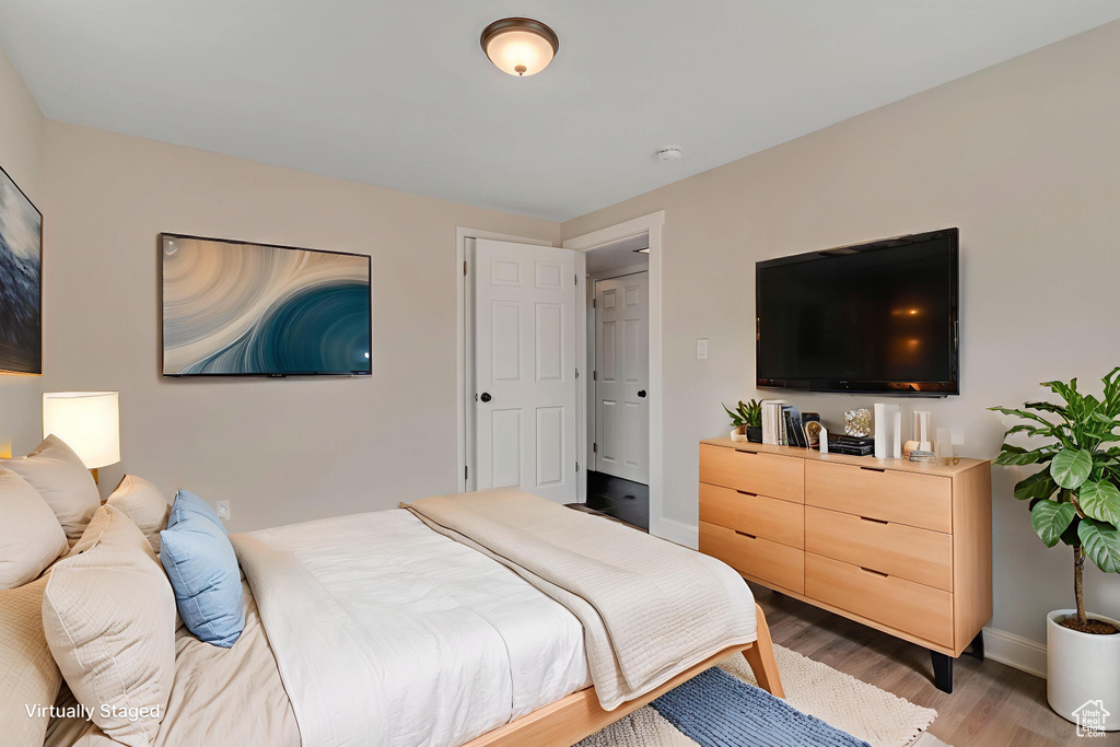 Bedroom with light wood finished floors and baseboards