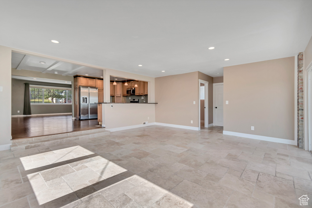 Unfurnished living room with stone tile floors and recessed lighting