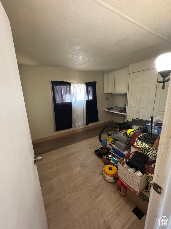 Laundry room featuring wood finished floors and a textured ceiling