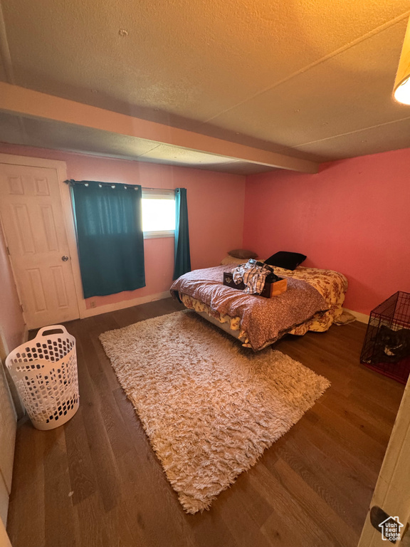 Bedroom with wood finished floors and a textured ceiling