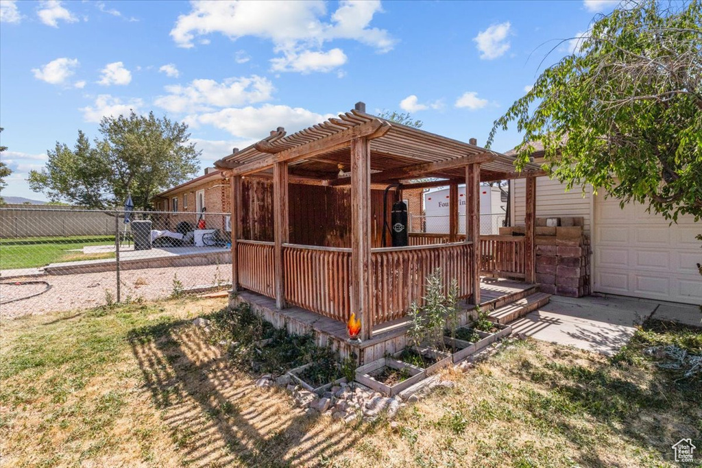 Back of house featuring a pergola and a garage