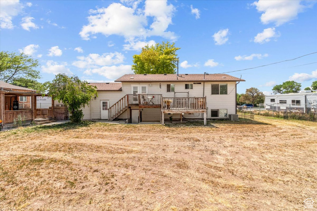 Rear view of property featuring a wooden deck and stairway