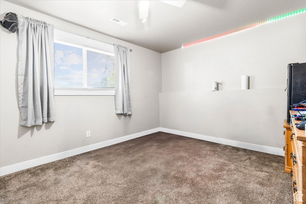 Empty room featuring carpet and a ceiling fan