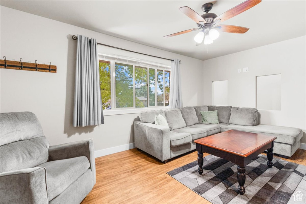 Living area with ceiling fan and light wood-type flooring