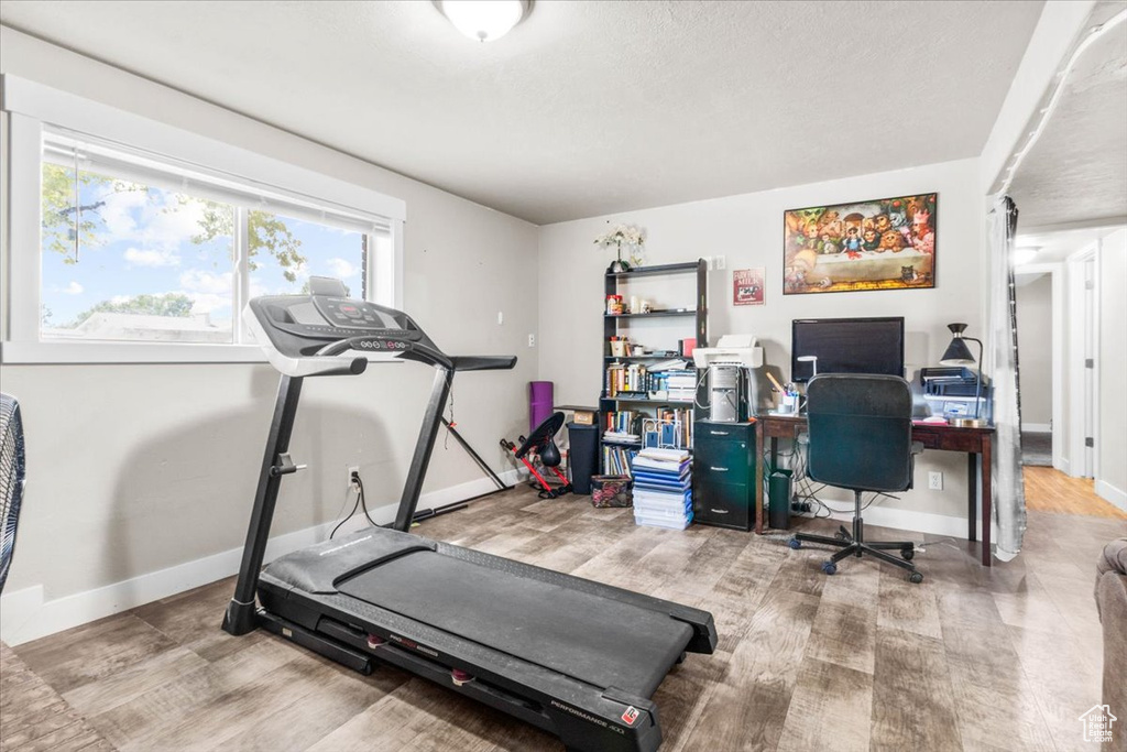 Exercise area featuring baseboards and wood finished floors