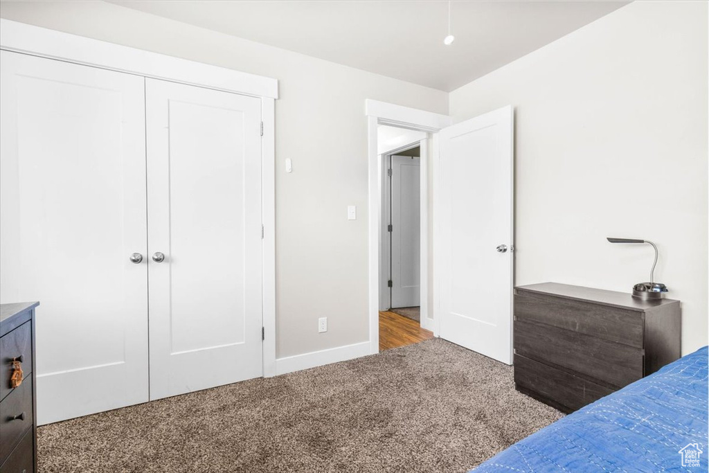 Carpeted bedroom featuring a closet and baseboards