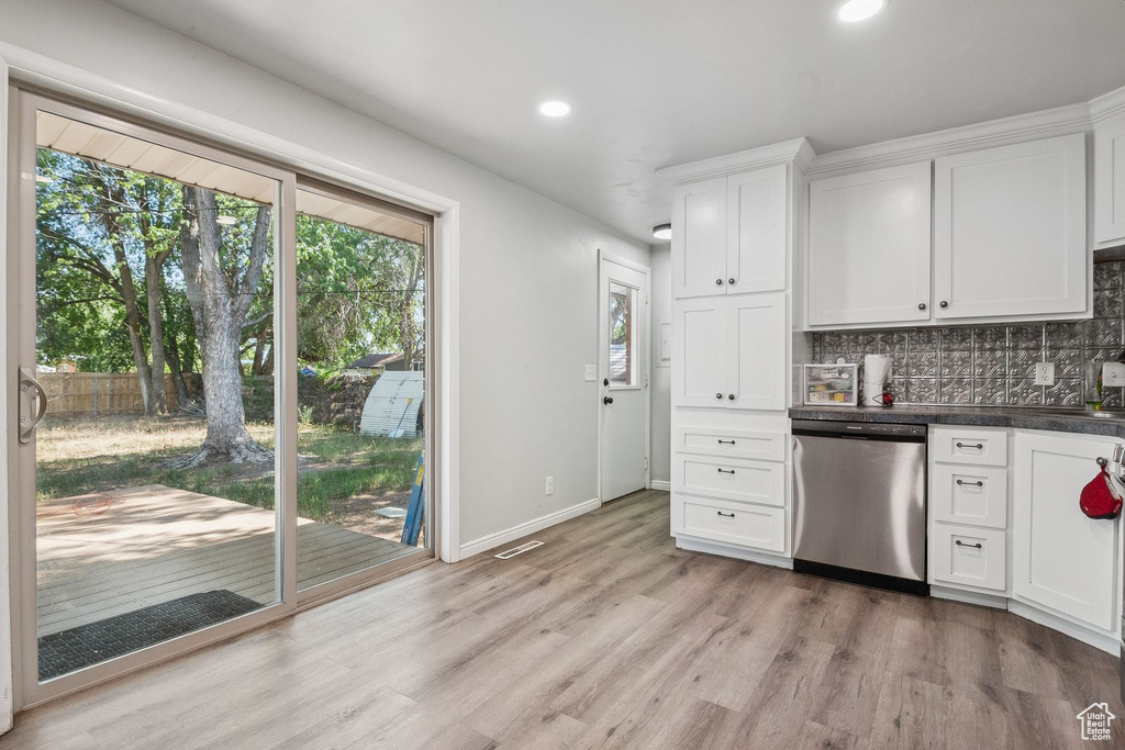 Kitchen featuring dishwasher, decorative backsplash, recessed lighting, light wood-type flooring, and white cabinets