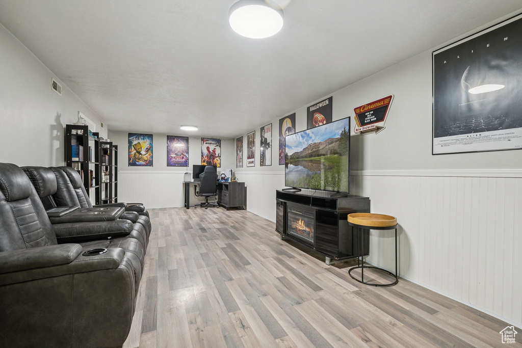 Living room featuring wood finished floors, an office area, and wainscoting
