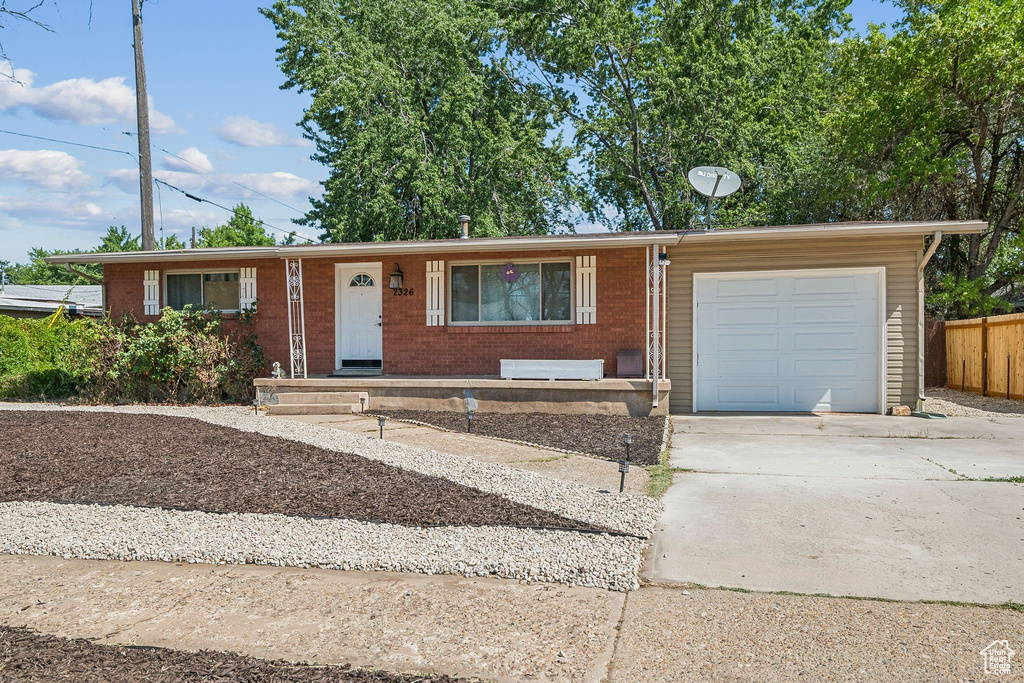 Single story home with a garage, concrete driveway, and brick siding